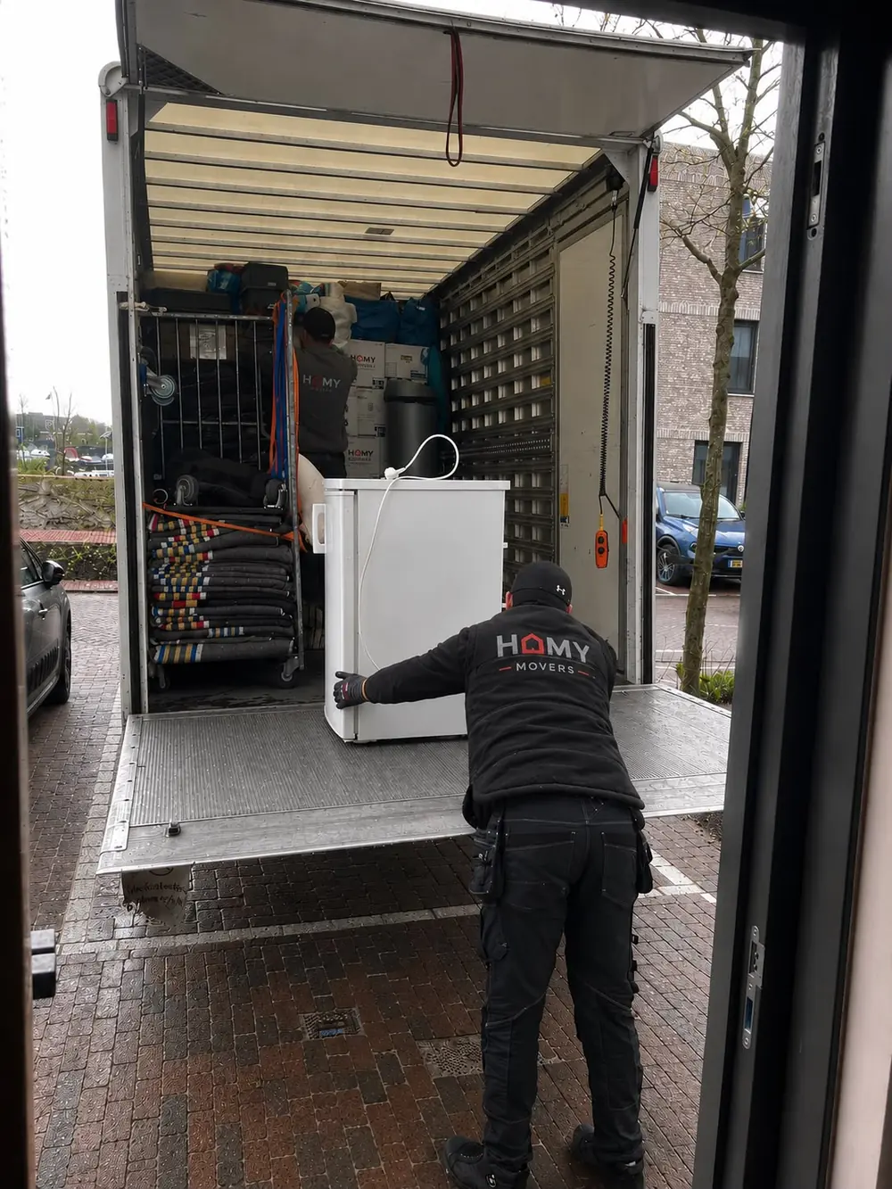 Verhuizer rijdt een koelkast de verhuiswagen in