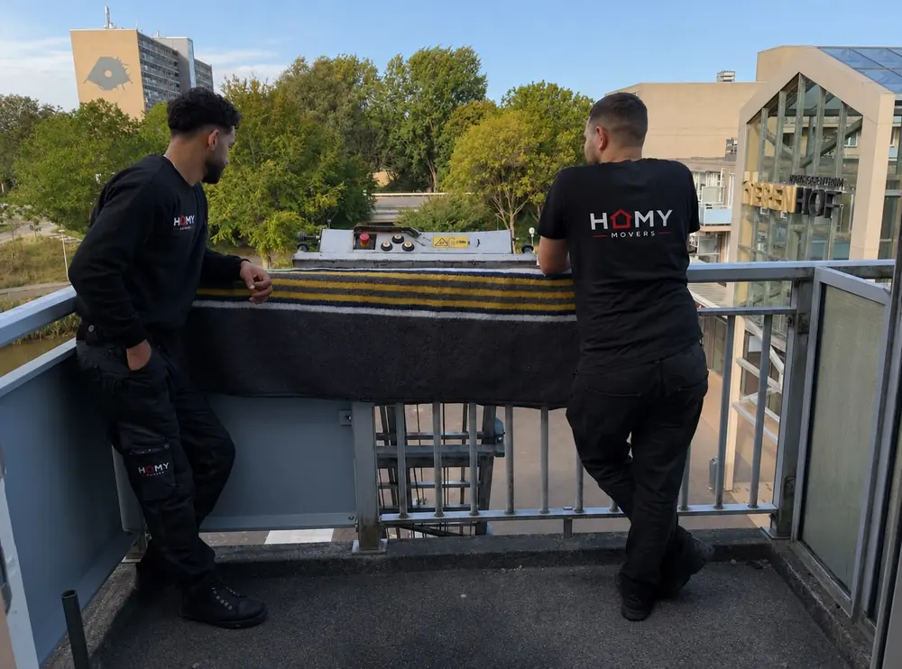 Verhuizers bij een verhuislift op een balkon